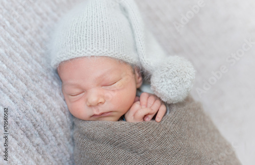 sleeping newborn boy in a hat