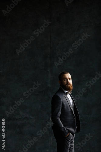 Handsome caucasian businessman dressed in the suit near the window in the loft interior studio