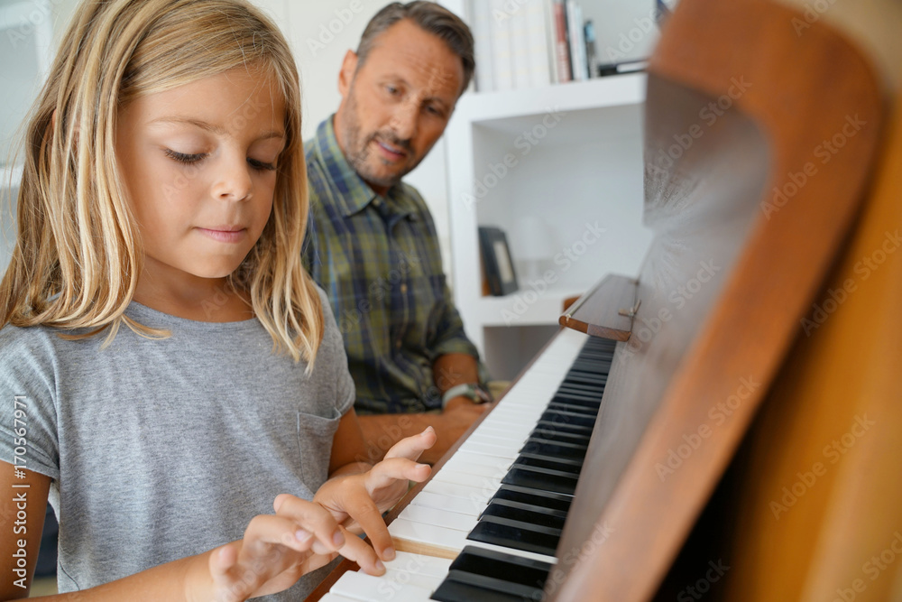 Fototapeta Mała dziewczynka z nauczycielem bawić się pianino