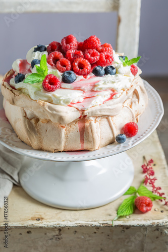Homemade and rustic Pavlova cake with raspberries and meringue
