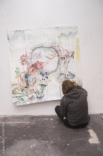 Man drawing on paper pinned to wall