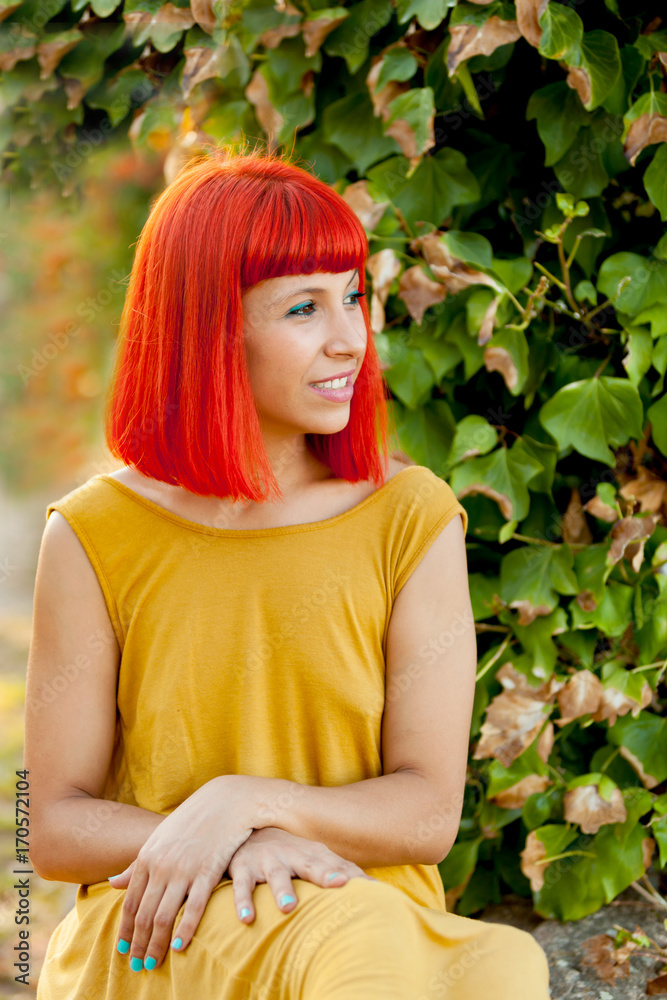 Pensive red haired woman in a park Pensive red haired woman in a park