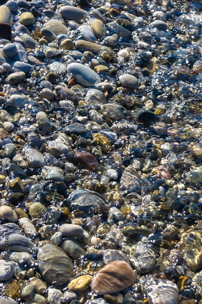 sea pebble beach with multicoloured stones, waves with foam sea pebble beach with multicoloured stones, waves with foam