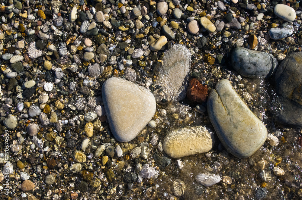 sea pebble beach with multicoloured stones, waves with foam sea pebble beach with multicoloured stones, waves with foam