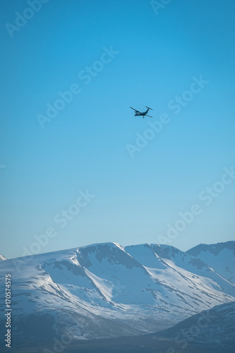 Small passenger plane over a remote snowy mountains.