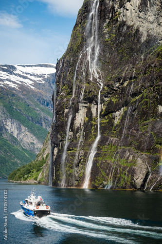 Cruise boat at the famous geiranger fjord waterfalls in norway.