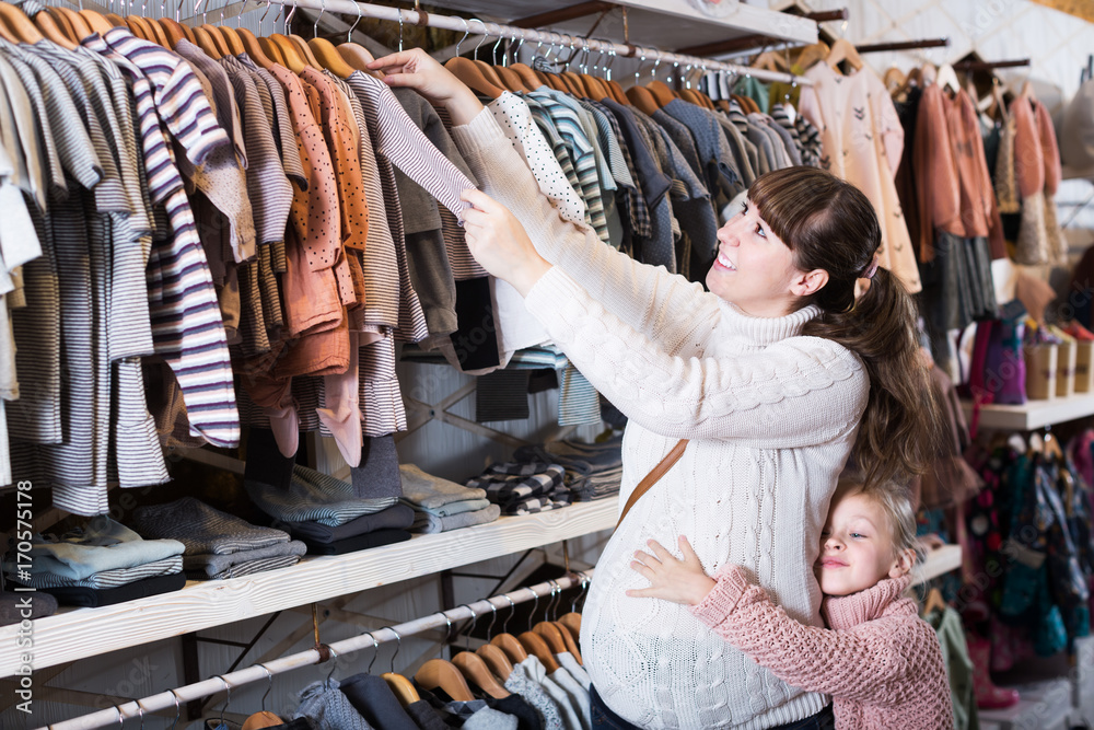 Pregnant woman examining baby's clothes