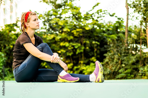 althletic woman with dreadlocks is having a rest after exercises photo