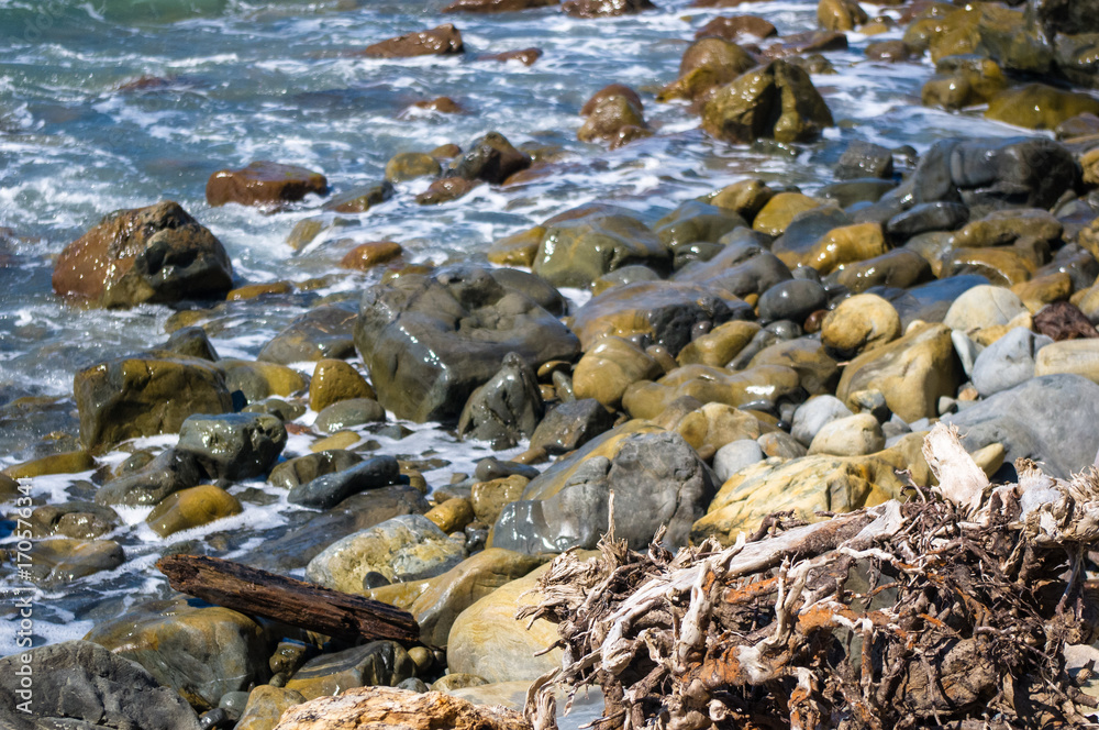 rocky sea shore with pebble beach, waves with foam rocky sea shore with pebble beach, waves with foam