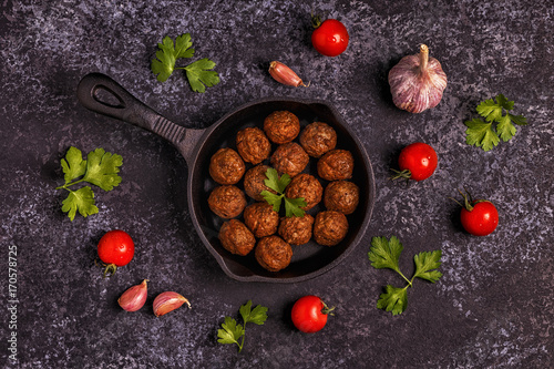 Roasted meatballs with tomatoes, garlic and parsley.
