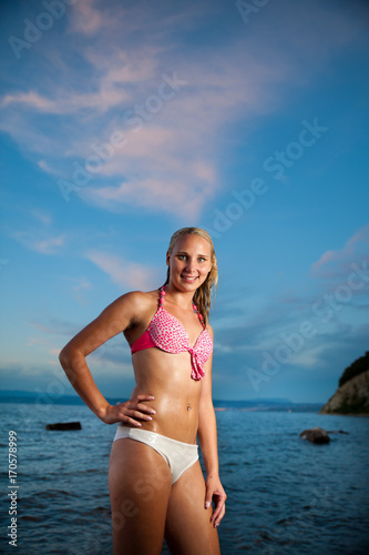 Young woman on the beach at sunset on a hot summer day