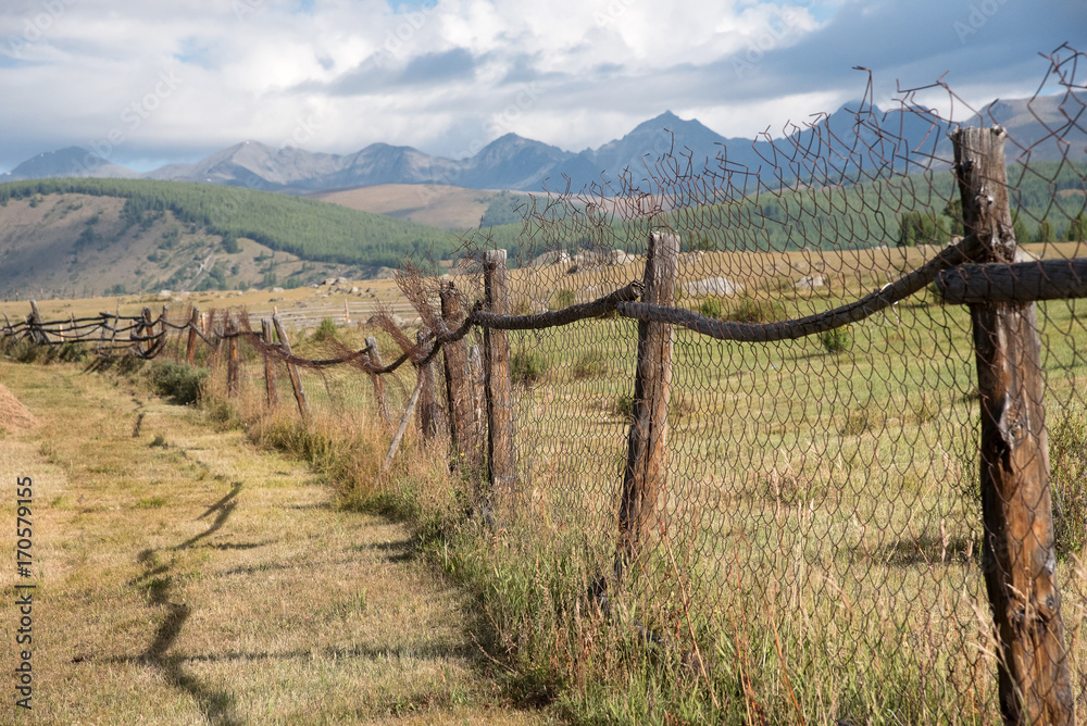 Obraz premium Wooden fence in the highlands and sky with clouds
