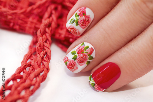 Red French manicure with a design of roses on a white background.