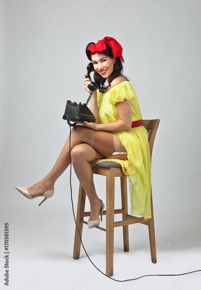 Fototapeta premium Beautiful woman speaking via vintage phone.
