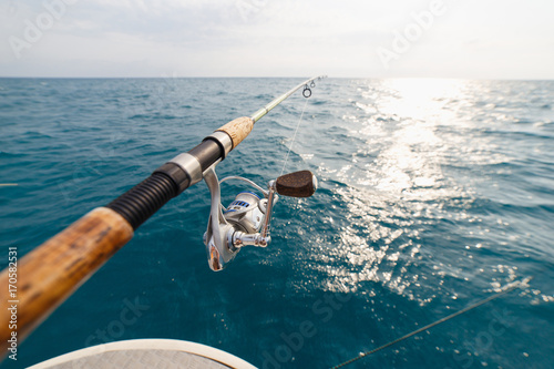 Fotografia Fisherman fishing rod on the sunset closeup