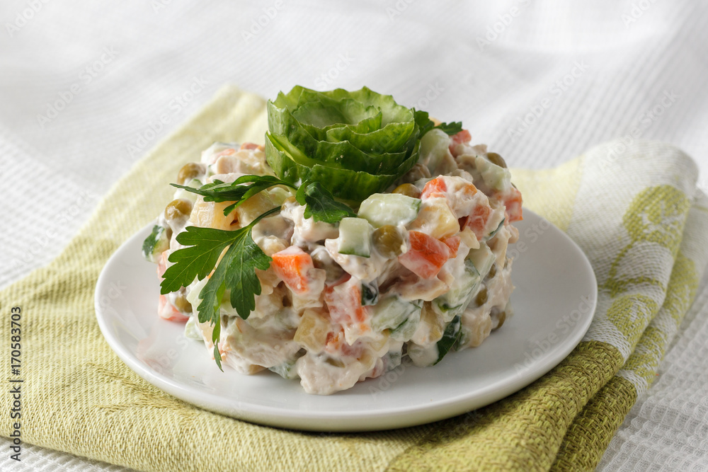 Russian salad Olivier on a white plate Russian salad Olivier on a white plate