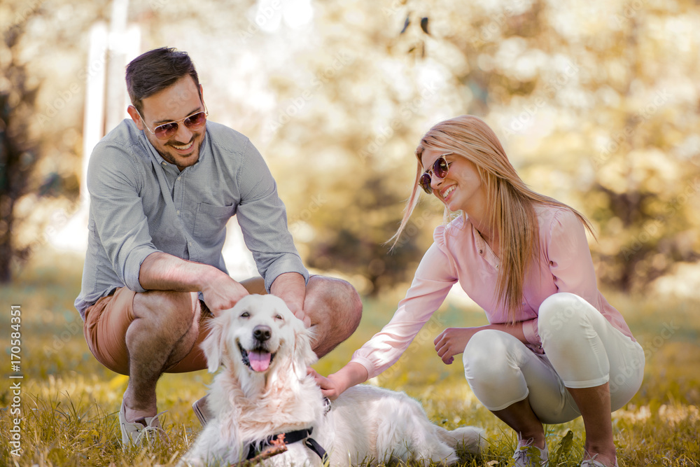 Fototapeta premium Couple with their dog in the park on a sunny day.