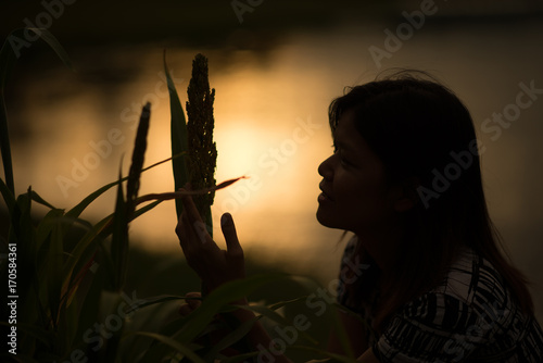 Woman standing in the park sunset looing in the sky ,silhouette