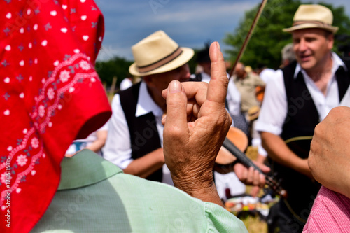An older lady playing with country music in the field, Zrenjanin,Serbia,10th of July,2017.
