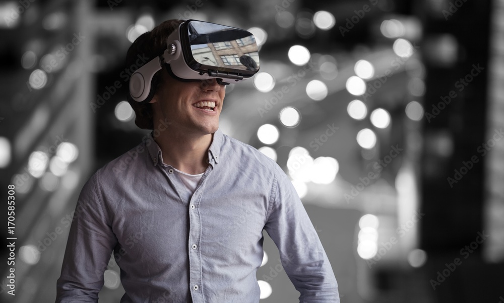 Composite image of smiling young man wearing virtual reality Composite image of smiling young man wearing virtual reality