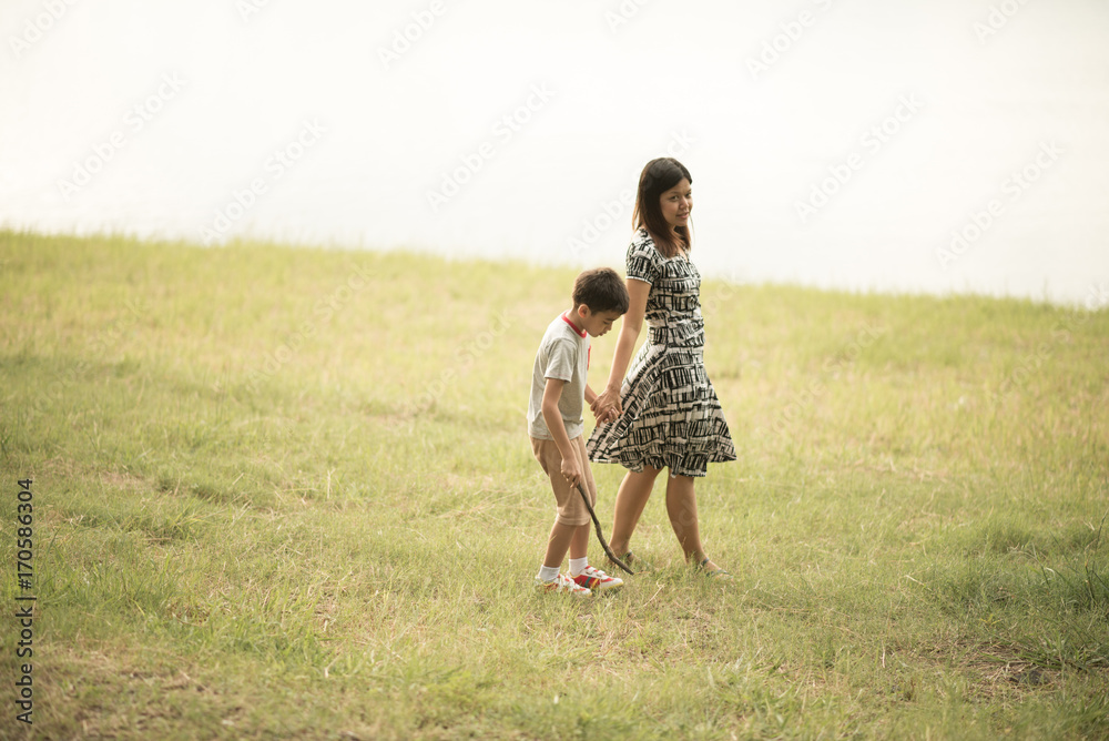 Single mother walking together in the park sunset time happiness