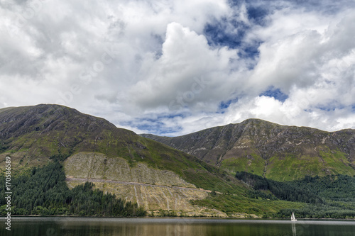 A small white sail boat on the waters of Loch Lochy in the highlands area of Scotland.