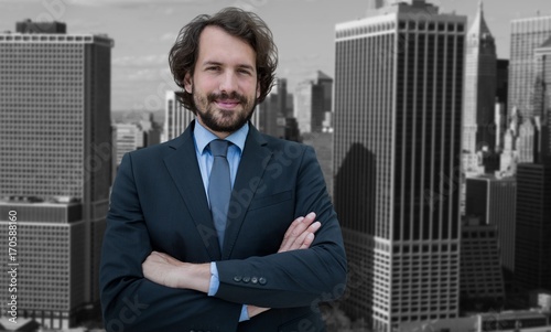 Composite image of portrait of businessman standing with arms photo