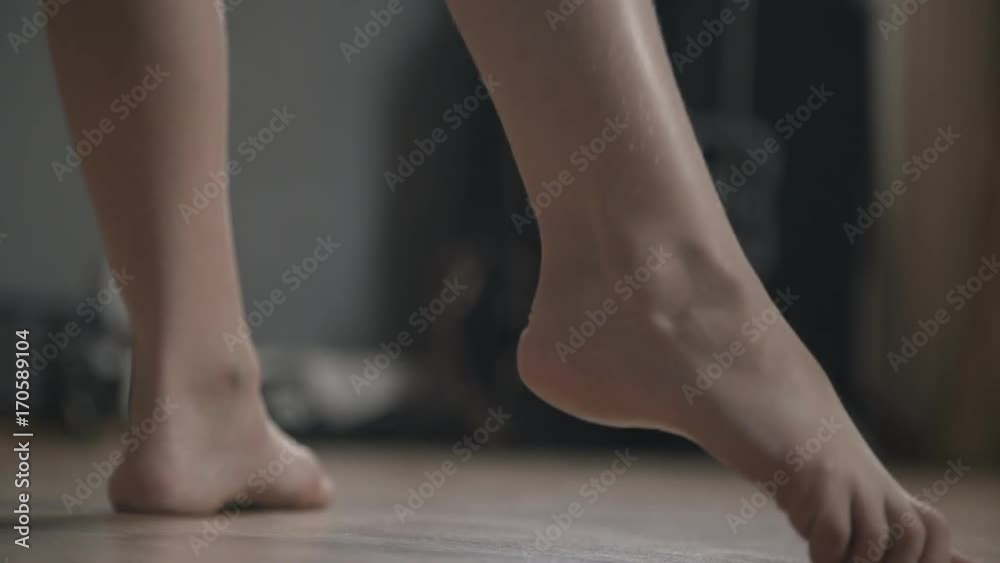 Footsteps of a little girl's dancer: she pulls her toe and draws a circle. Dance pas: dance rehearsal. Dance movements and choreography. Close-up Footsteps of a little girl's dancer: she pulls her toe and draws a circle. Dance pas: dance rehearsal. Dance movements and choreography. Close-up