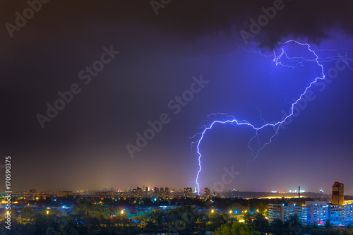 Lightning over the city at the summer storm. Dramatic  breathtaking atmospheric natural phenomenon.