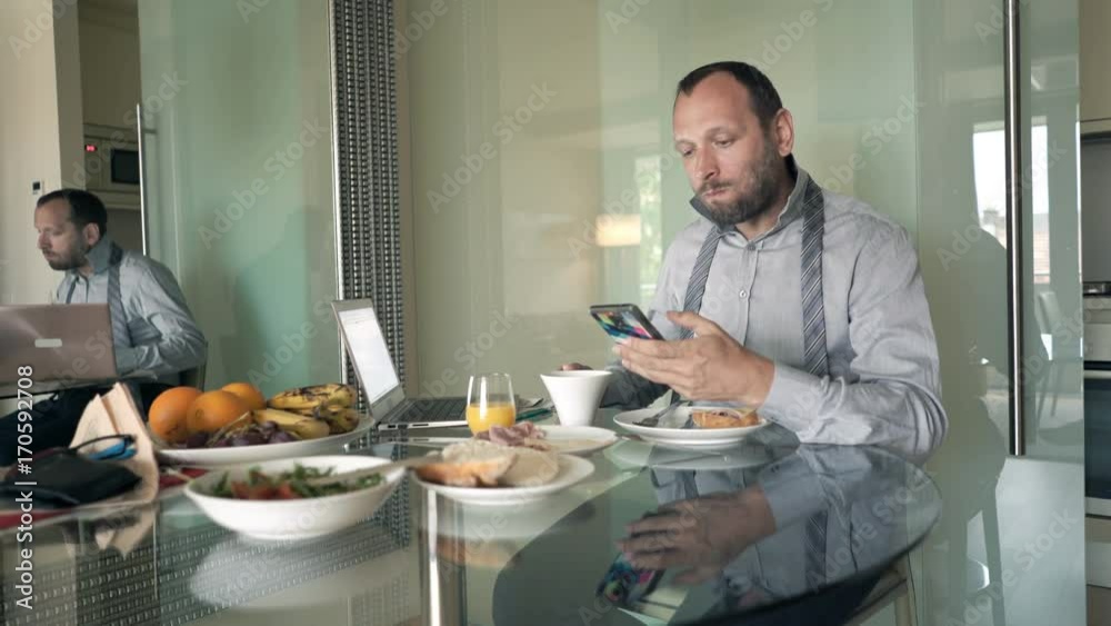 Young businessman texting on smartphone during breakfast at home
Young businessman texting on smartphone during breakfast at home