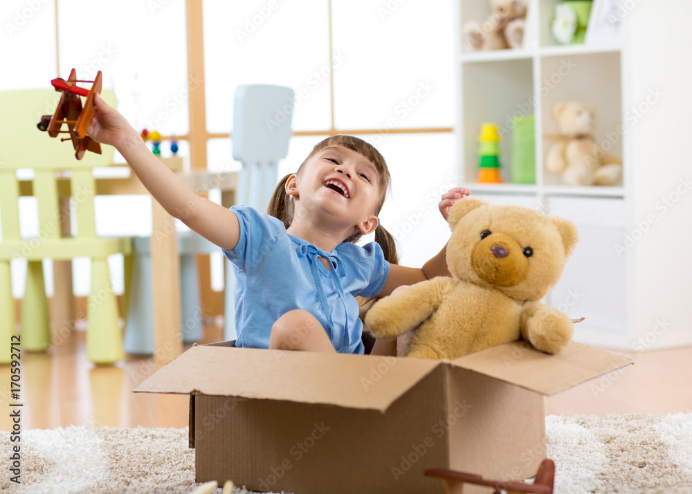 Fototapeta premium Pilot aviator child with a toy airplane plays at home in his room