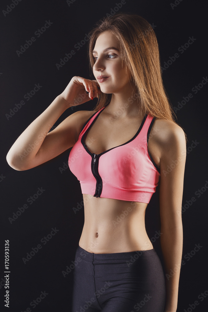 Beautiful fitness girl posing on black background