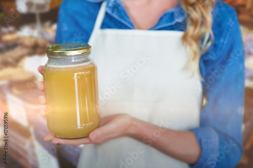 Composite image of midsection of woman holding jar