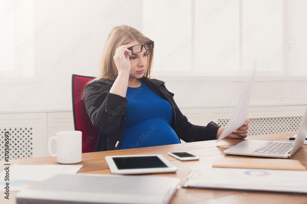 Young pregnant woman using smartphone at office Young pregnant woman using smartphone at office