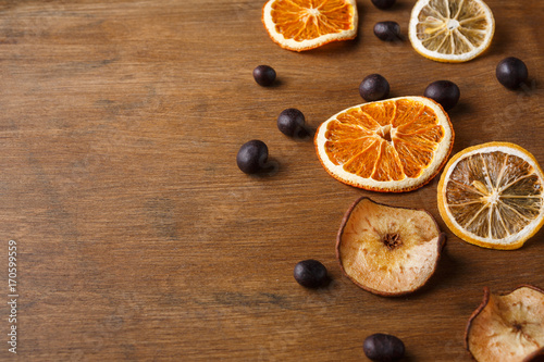 Slices of dried fruits on wooden board background