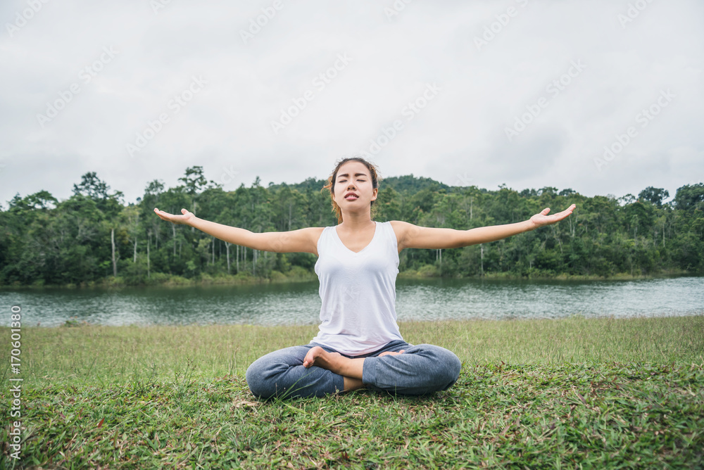 Asian women relax in the holiday. Play if yoga. on a green pasture. Asian women relax in the holiday. Play if yoga. on a green pasture.