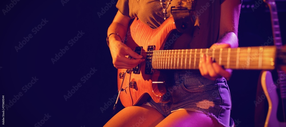 Obraz premium Mid section of woman playing guitar