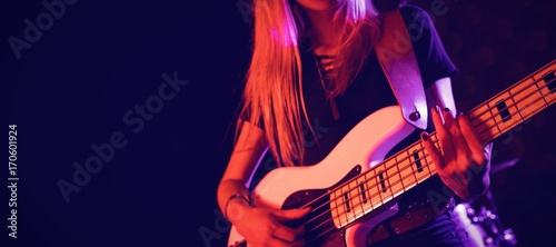 Beautiful female guitarist performing in nightclub photo