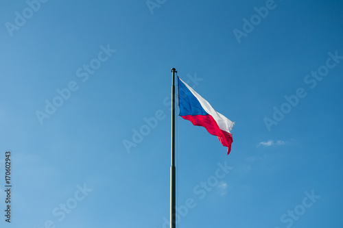 National flag of the Czech Republic. Symbol of country, state and nation is waving on the pole. Clear blue sky in the background