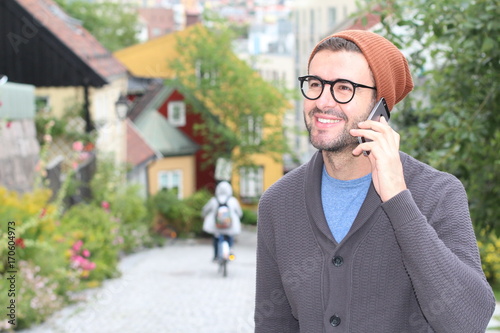 Hipster calling by phone outdoors with copy space
