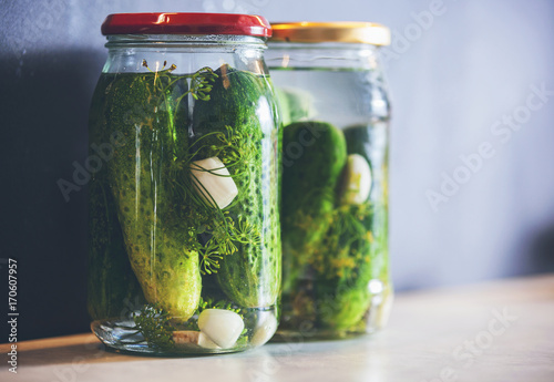 Pickled cucumbers in a jar with spices and herbs copy space