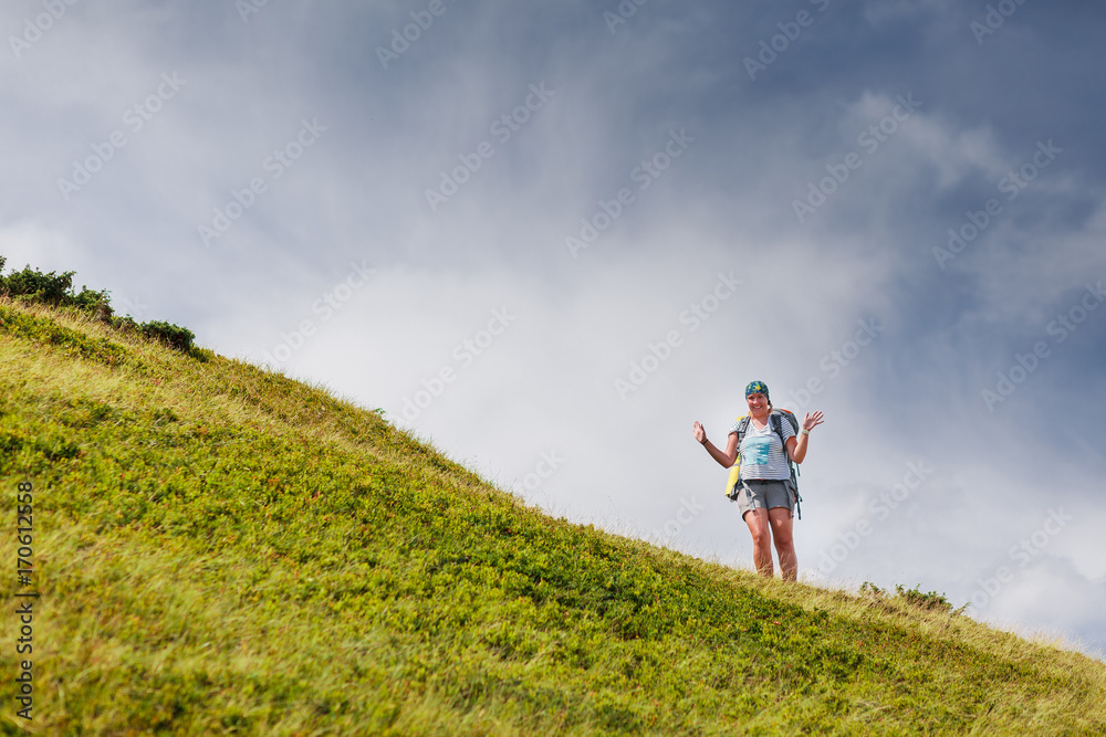 Woman hiking in mountains with big backpack