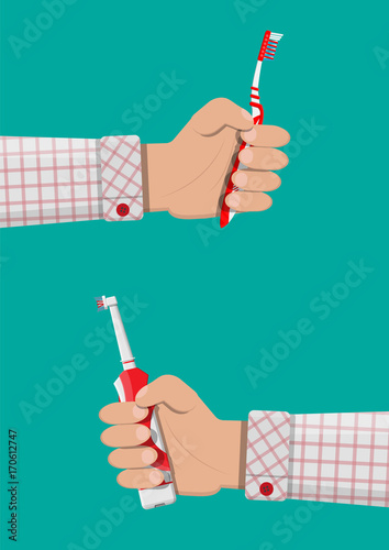 Electric and manual toothbrush in hand