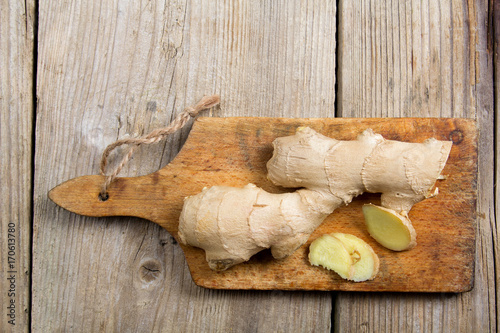 Raw ginger root on wooden background.