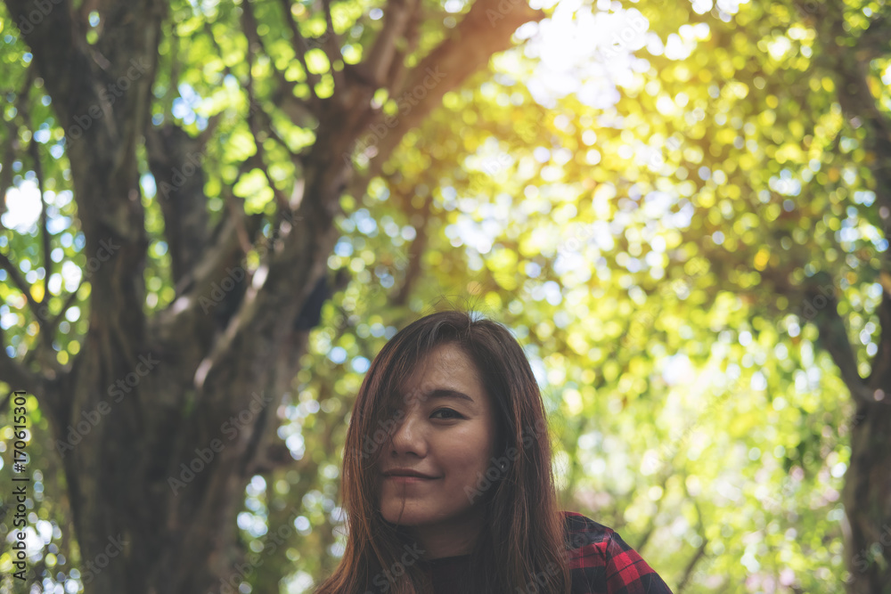 Closeup image of a beautiful Asian woman using and looking at smart phone with feeling bored while waiting for someone in modern green cafe Closeup image of a beautiful Asian woman using and looking at smart phone with feeling bored while waiting for someone in modern green cafe