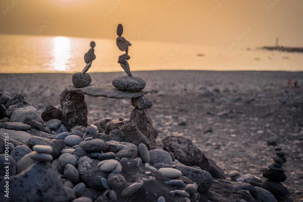 Skulpturen am Strand aus Steinen im Sonnenuntergang