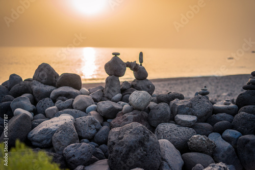 Skulpturen am Strand aus Steinen im Sonnenuntergang photo