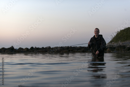 flyfishing man at dawn © bevisphoto