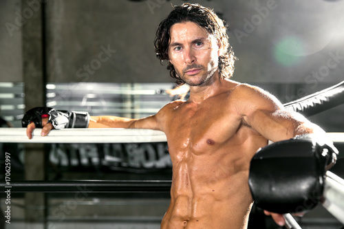 Portrait of a muscular male fighter with perfect physique defined muscles during boxing workout