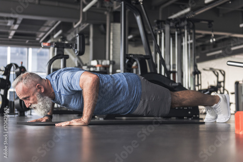 Concentrated old male is having workout